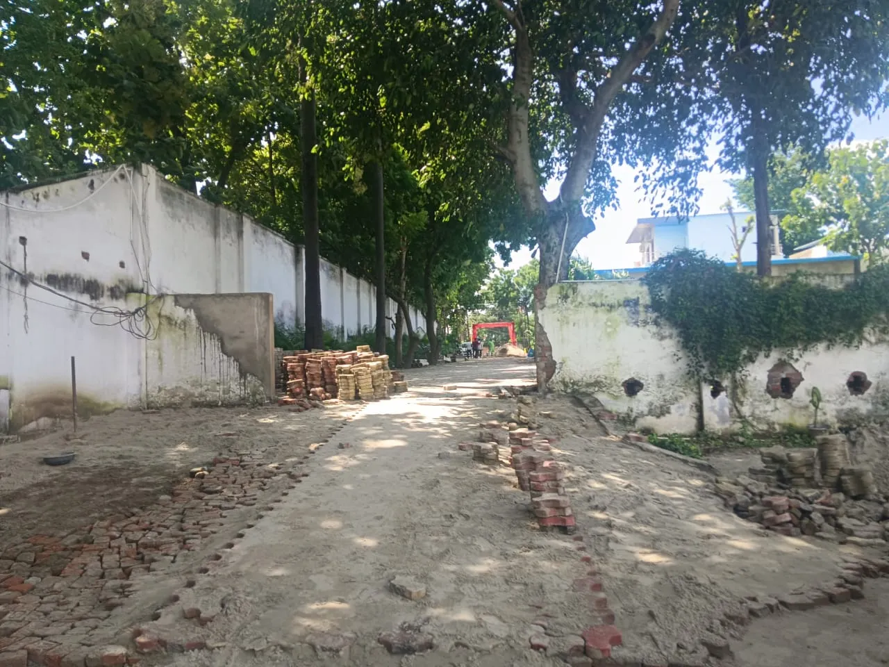 Garden pathway being laid with brick edging along a boundary wall