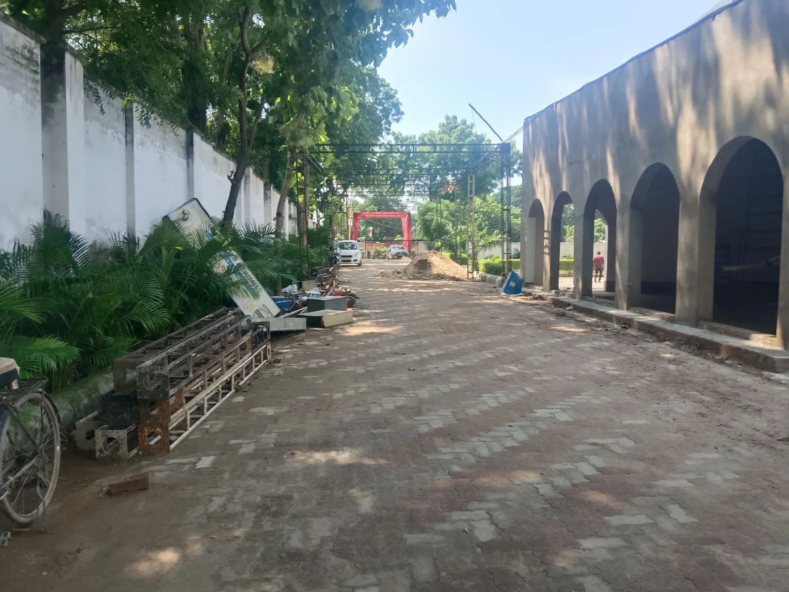 Paver walkway along an arched colonnade and boundary wall