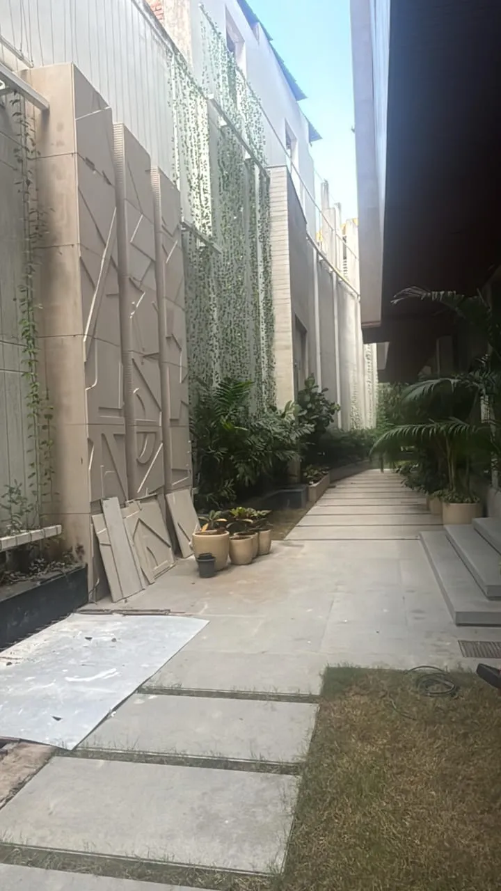 Side passage with green wall trellis panels and stone pavers