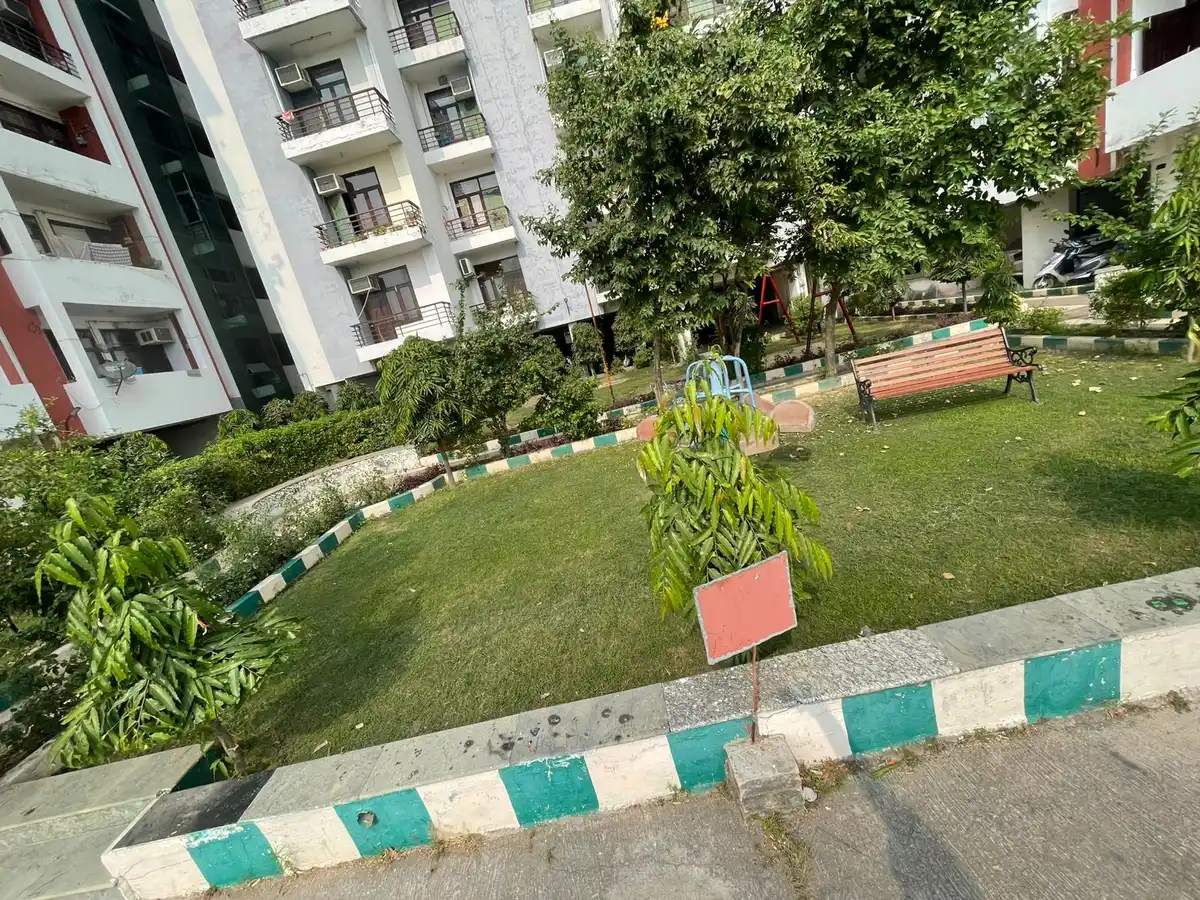 Society garden lawn with bench between apartment blocks