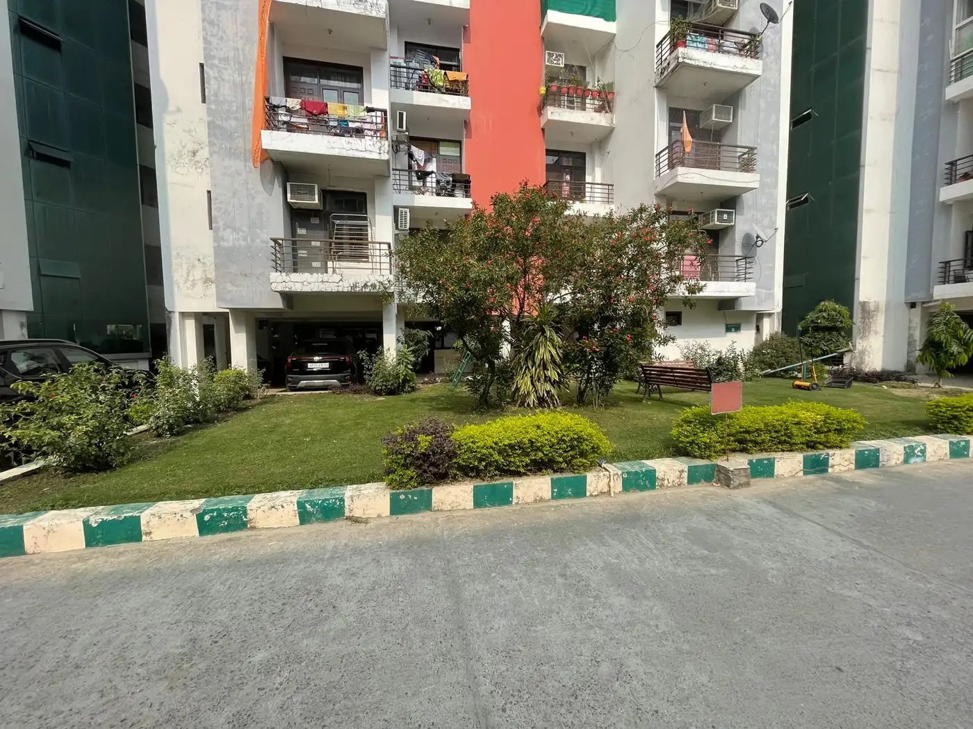 Society lawn with shrubs in front of apartment towers